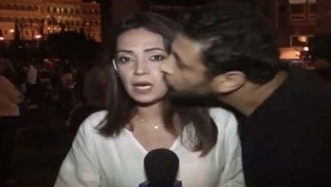Lebanese protester kisses reporter while live on air
