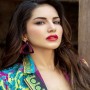 Sunny Leone takes aim with a bow and arrow while playing archery