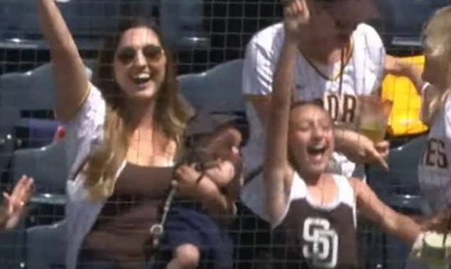 Woman Holding A Baby In Her Hand Catches The Ball With Another Hand