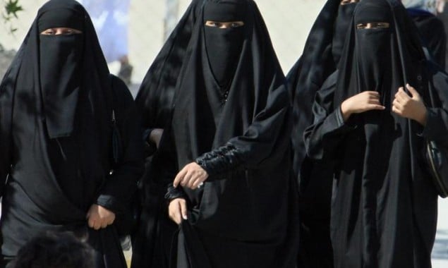Saudi women cross a street