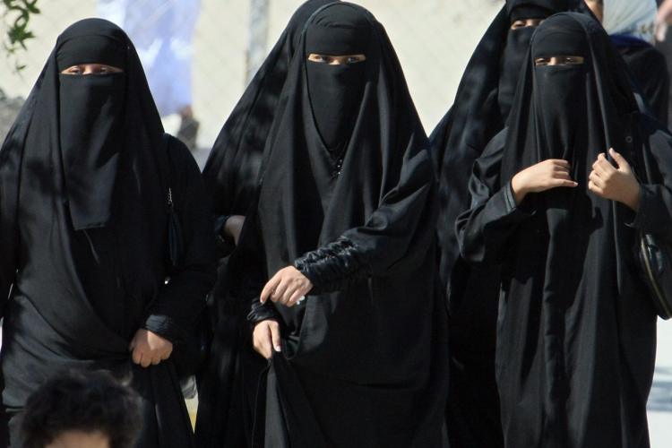 Saudi women cross a street