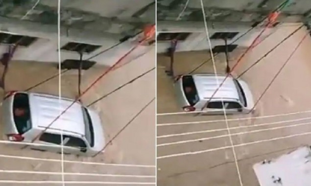 Footage of a car tied with rope to keep it from being in floodwater