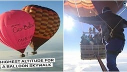 Man walking between hot air balloons suspended over 6,500 meters