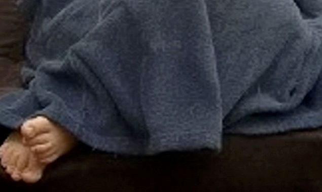 A wanted guy is discovered hiding under a blanket with his feet protruding