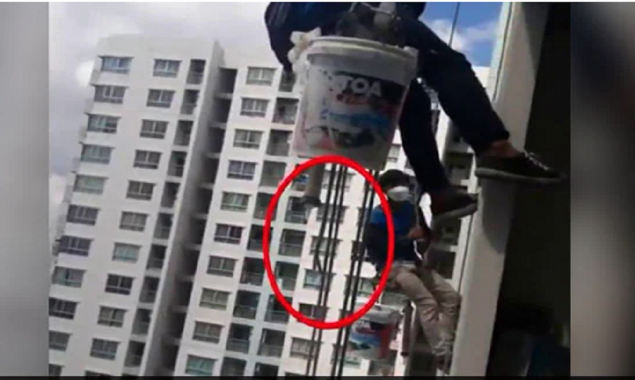 Woman cuts the support rope of two workers left dangling from 26th floor