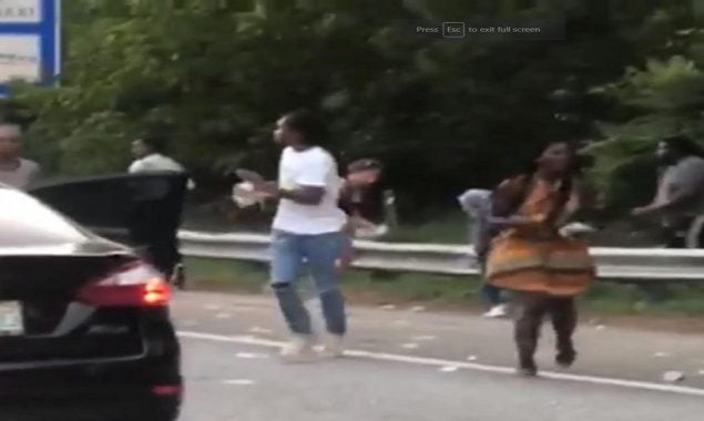 Commuters pull over on US freeway to pick up the cash over the road