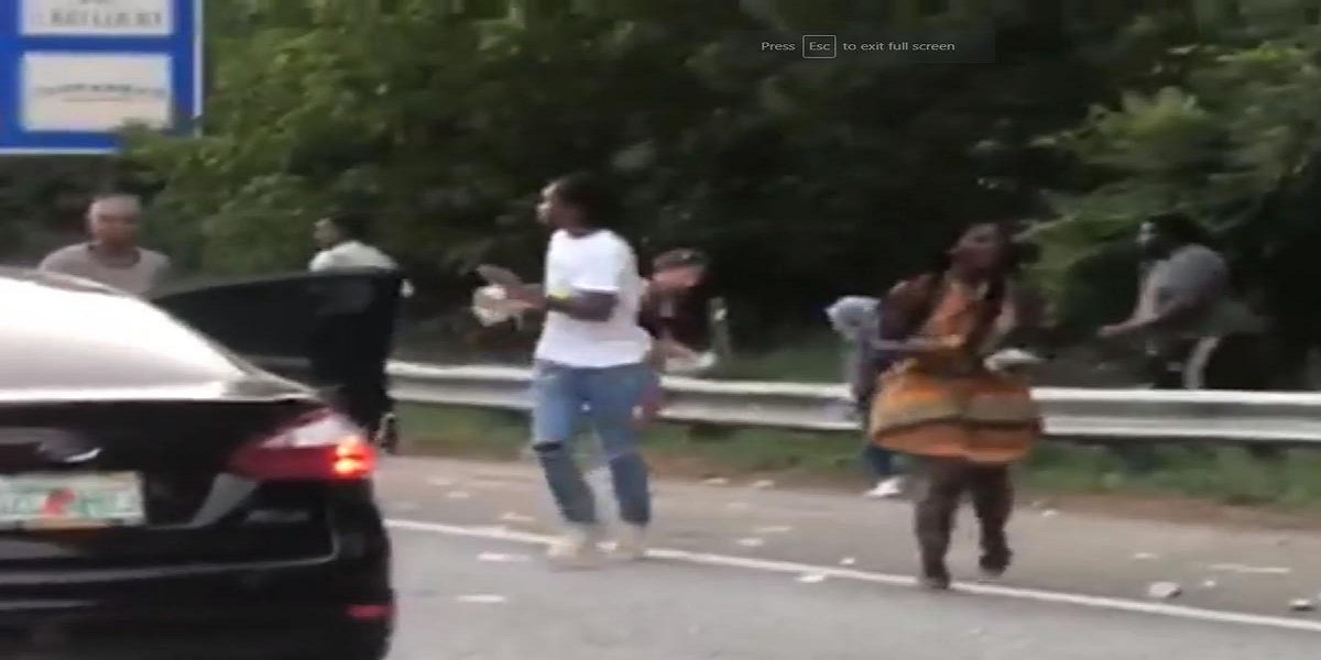 Commuters pulls over on US freeway to pick up the cash over the road