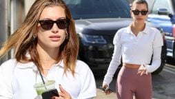 Hailey Bieber flaunts her toned body in a cropped top and leggings