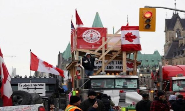 Canada truckers defy order to clear key bridge as protests swell