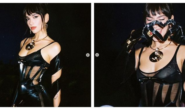 Dua Lipa puts on a racy show, grabbing her cleavage through a tight black jumpsuit with semi-transparent panels and sultry snaps