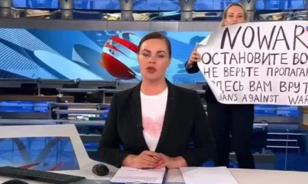 A brave anti-war activist storms Russia’s main propaganda news show, waving a sign that reads, ‘They’re Lying to You.’