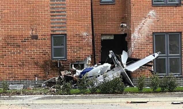 A plane crashes into a block of flats, and the pilot is transported to the hospital