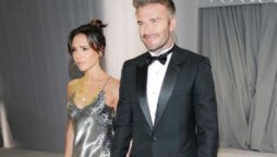 Victoria Beckham smiles as she shows off her full-length wedding gown