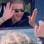 As he leans out of his high-security car to meet children, Prince Harry recoils after receiving a static charge following a high-five with a fan