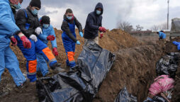 As a town buries its dead in a mass grave, Russia bombards Ukraine’s east