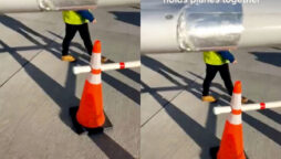A worker at the airport displays tape that “holds planes together.”