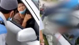 The elderly driver in the horrifying footage is seen driving with a dead biker on the roof