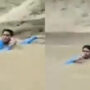 Pakistani reporter stands amid floodwater to report
