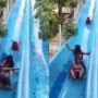 Sliding in High-speed a girl pushes girls stuck on water slide