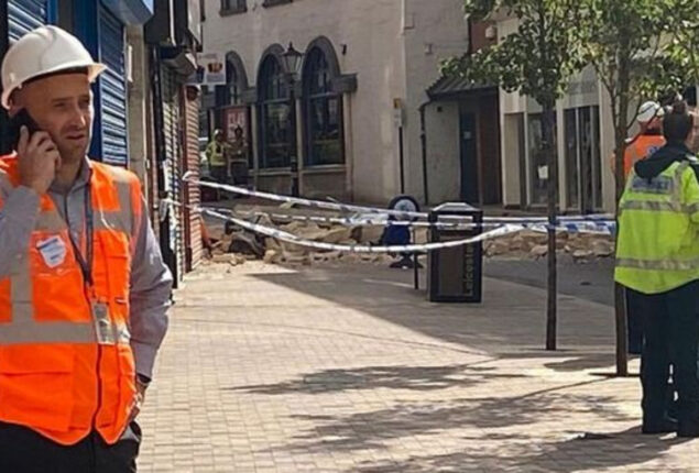 Component of a building collapses into a city street in Leicester