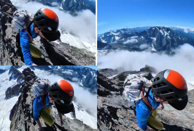 Climber traversing narrow mountain