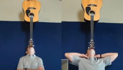 balances guitar on chin