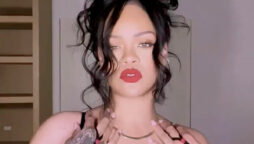Rihanna in this steamy video wearing a corset dress with thigh-high boots