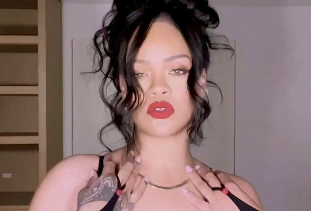 Rihanna in this steamy video wearing a corset dress with thigh-high boots