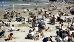 Man holding phone in 1940s beach photo proves time travel is real
