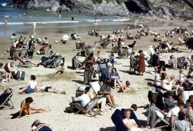 Man holding phone in 1940s beach photo proves time travel is real