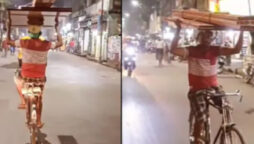 Viral Video: Man balances planks on his head while riding a bicycle