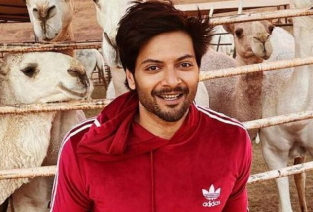 Ali Fazal poses with Steven Spielberg and Tom Cruise during the Oscars luncheon